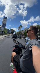 Man rides red scooter through Kuta streets