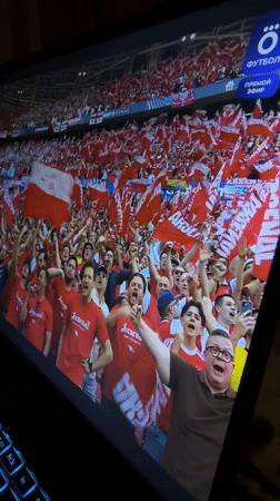 Stadium performance with crowd captured on laptop screens
