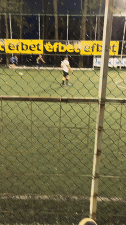 Soccer match observed through fence in Karlovo, Bulgaria