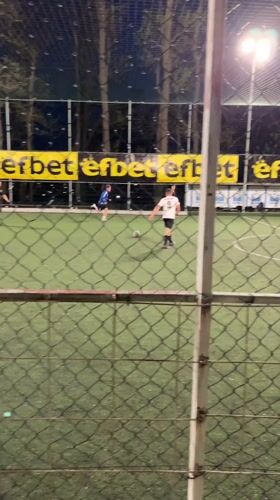 Soccer match observed through fence in Karlovo, Bulgaria