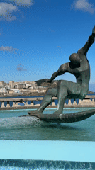 Sun, sand, and a surfer statue on A Coruña's waterfront