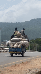 Men ride atop loaded truck in Adankolo Nigeria