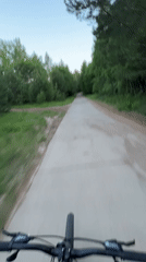Cyclist rides tree-lined path in Noviy, Russia