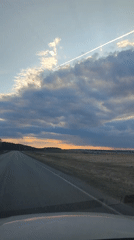 Vehicle travels rural road at dusk near Perevoznoe, Russia