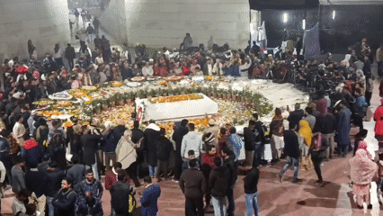 Crowd gathers around draped structure in Dhaka