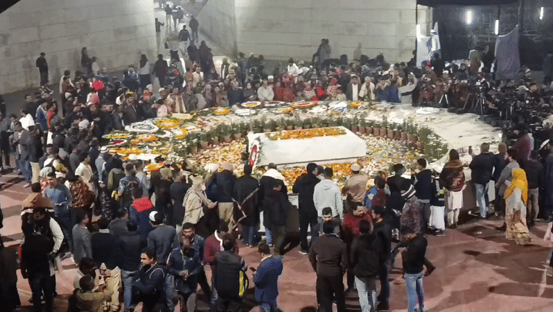 Crowd gathers around draped structure in Dhaka