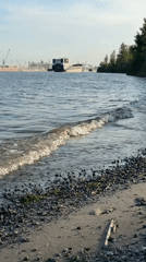 Beachgoers enjoy Don River shore amid port activity in Rostov