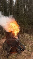 Person feeds barrel fire in Russian woods, flames erupt