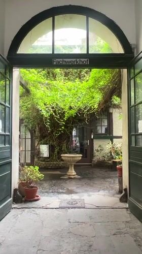 Berlin courtyard with fountain captured through Fachwerkhof archway