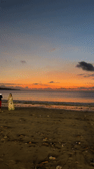 Tourists enjoy typical sunset evening at Kuta Beach, Bali