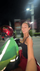 Woman rides Grab motorcycle taxi in Pattaya City