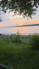 Woman stretches by water during peaceful sunset moment