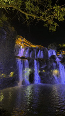 Purple-lit waterfall illuminates Furong Ancient Town at night