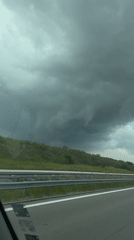 Vehicle drives Bulgarian highway under threatening storm clouds