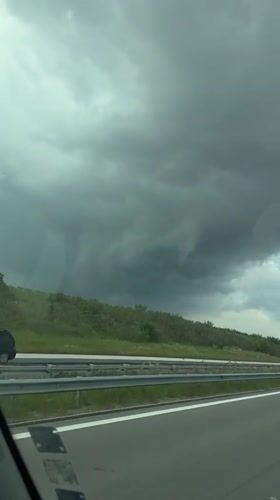 Vehicle drives Bulgarian highway under threatening storm clouds
