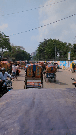 Morning street traffic with decorated rickshaws observed in Dhaka
