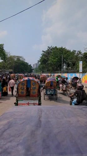 Morning street traffic with decorated rickshaws observed in Dhaka