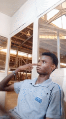 Young man photographed making gestures in Kakuri Gwari office