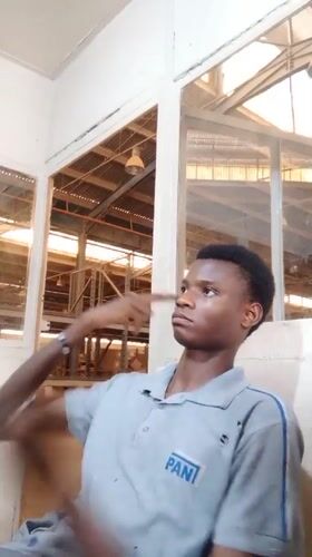 Young man photographed making gestures in Kakuri Gwari office