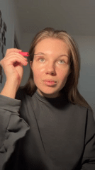 Woman applies makeup during evening hours in Belgrade suburb