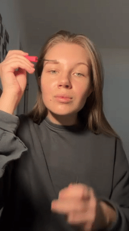 Woman applies makeup during evening hours in Belgrade suburb