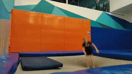 Boy performs backflip during indoor trampoline session
