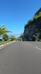 Morning traffic flows along scenic coastal road in Kuta Selatan