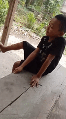 Two kids snacking and playing outdoors in rural Kerumutan