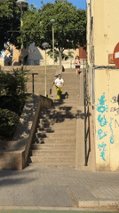 Scooter rider descends stairs, crosses street in Badalona