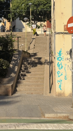 Scooter rider descends stairs, crosses street in Badalona
