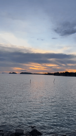 Sunset captured over calm waters in Baan Tai, Thailand