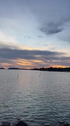 Sunset captured over calm waters in Baan Tai, Thailand