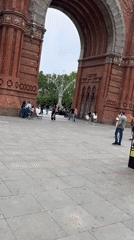 Crowds gather at Barcelona's Arc de Triomf amid cloudy weather