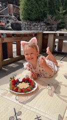 Toddler enjoys fruit snack on sunny deck in Wisła