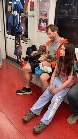 Child plays on handrails during Milan Metro evening commute