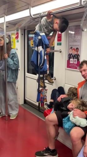 Child plays on handrails during Milan Metro evening commute
