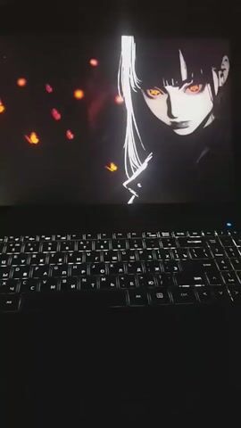 A laptop is open in a dark room. The screen displays a black and white anime-style image of a woman with long white hair, bangs, and glowing orange eyes. Small orange shapes resembling butterflies flicker around her. Below the screen is a backlit keyboard with white lettering. The keyboard layout is a mix of English and Cyrillic characters. The overall environment is dark, highlighting the screen and keyboard.