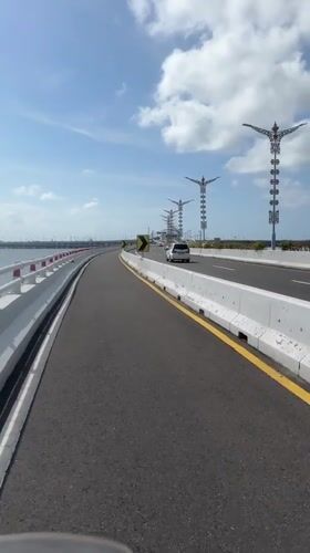 Motorcycle rider crosses bridge in South Denpasar