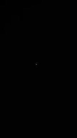 The video shows a small, faint, twinkling light in the center of a black screen. The light flickers and changes color slightly.
