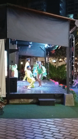 Nighttime outdoor performance features three performers in Porlamar, Venezuela