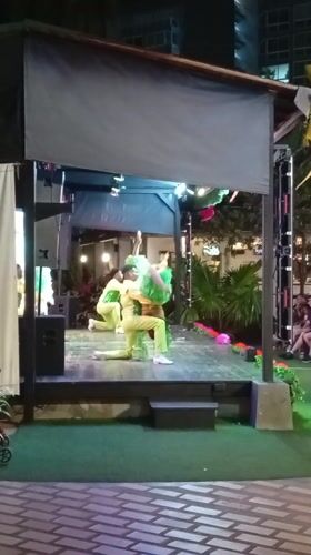 Nighttime outdoor performance features three performers in Porlamar, Venezuela