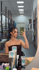 Woman takes morning mirror selfies while styling hair in Krasnoyarsk