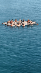 Paddleboarders gather in floating circle formation on calm water