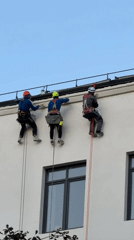 Rope-suspended workers clean or maintain a Moscow building facade.