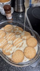 Someone prepares layered biscuit dessert with condensed milk in Barcelona