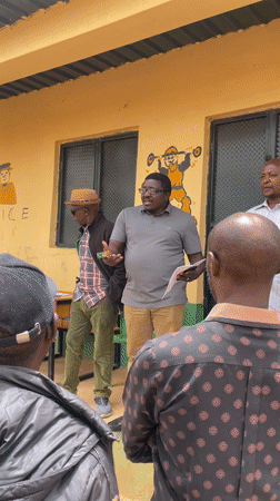 Community gathering with documents outside police building in Bukuru
