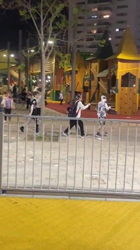 Children play with foam at nighttime playground in Kiryat Motzkin