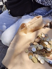 Person counts money on bench in Barcelona