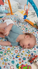Baby enjoys tummy time on colorful playmat in Russia