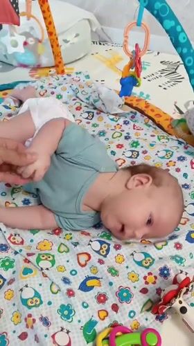 Baby enjoys tummy time on colorful playmat in Russia